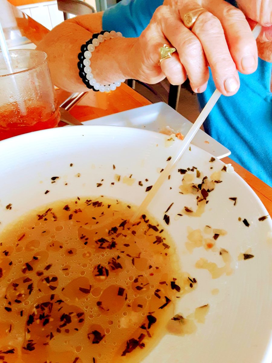 A woman sucks broth from a straw