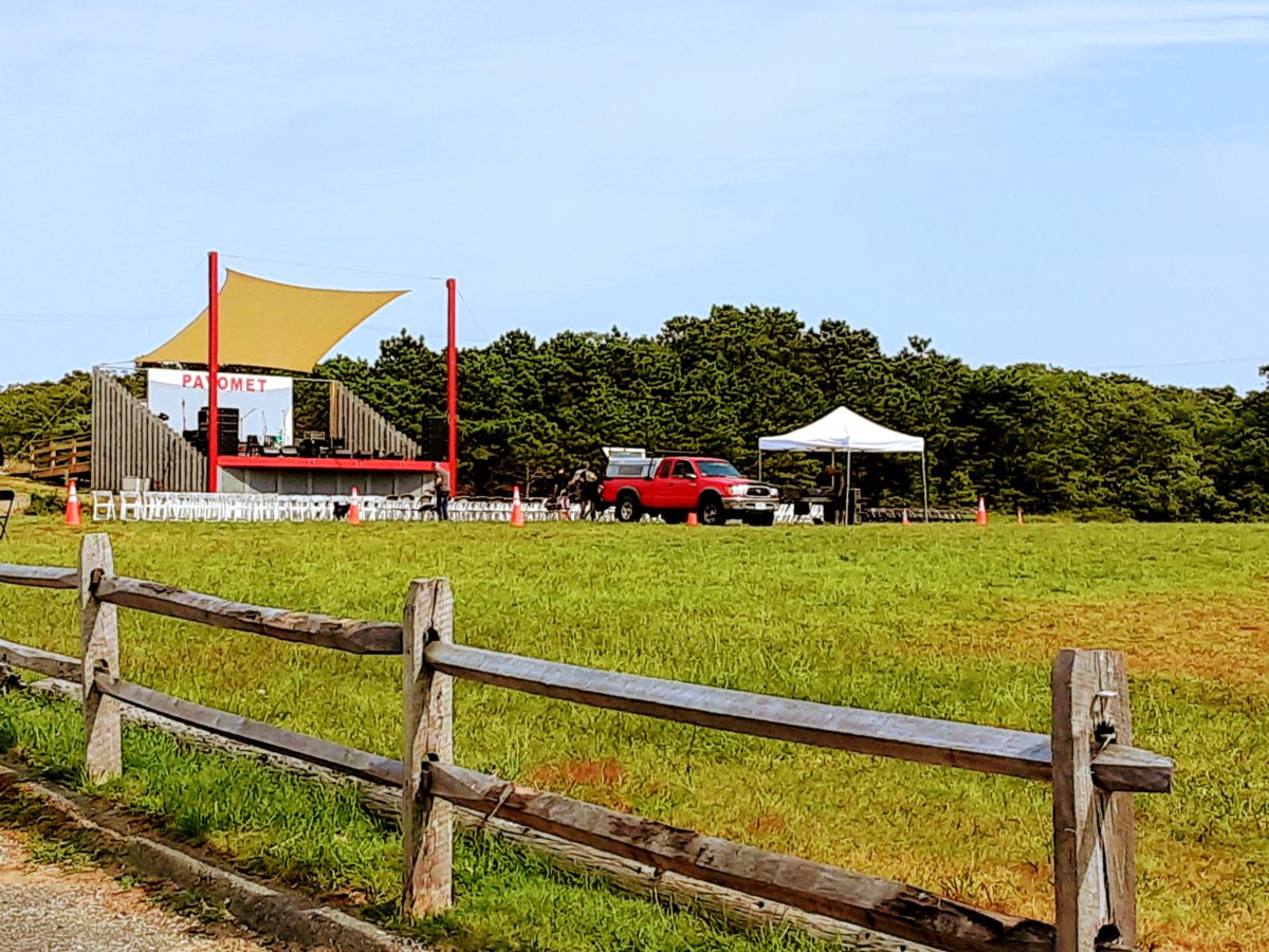 A stage overlooks a great lawn with chairs