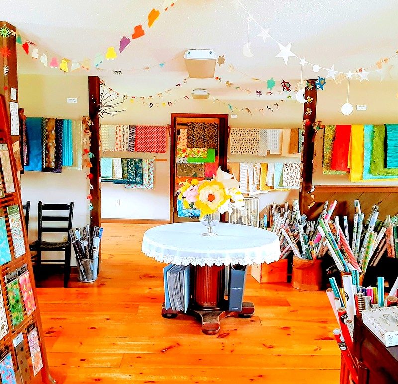 The interior of a materials and cards shop is shown