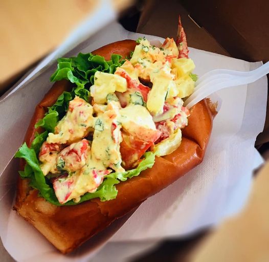 A lobster roll with lettuce, mint and Curry Mayo is shown